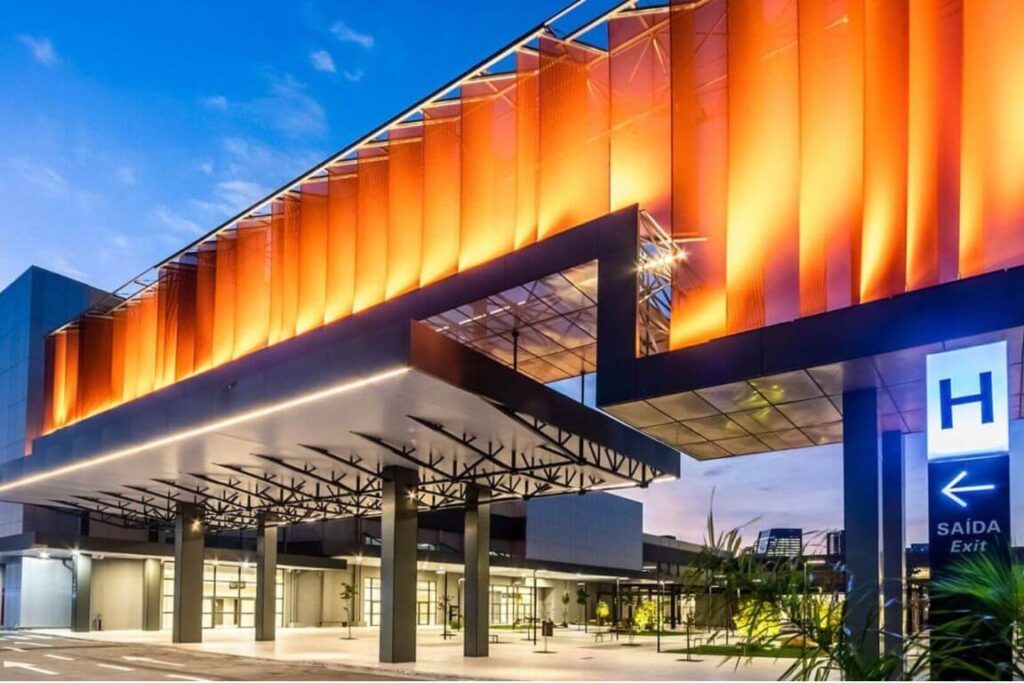 Fachada externa iluminada da entrada principal do pavilhão Transamerica Expo Center em São Paulo.