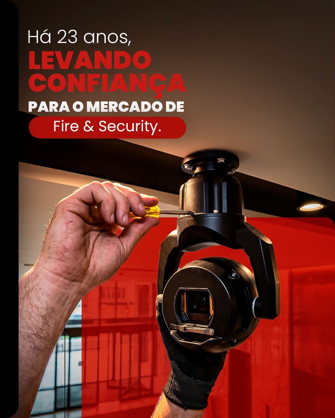 Técnico realizando a instalação e ajuste de câmera de monitoramento profissional para o mercado de Fire e Security.
